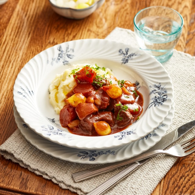 Grieks stoofvlees met zilver uitjes, romige aardappelpuree met olijfolie Grieks stoofvlees met zilver uitjes, romige aardappelpuree met olijfolie